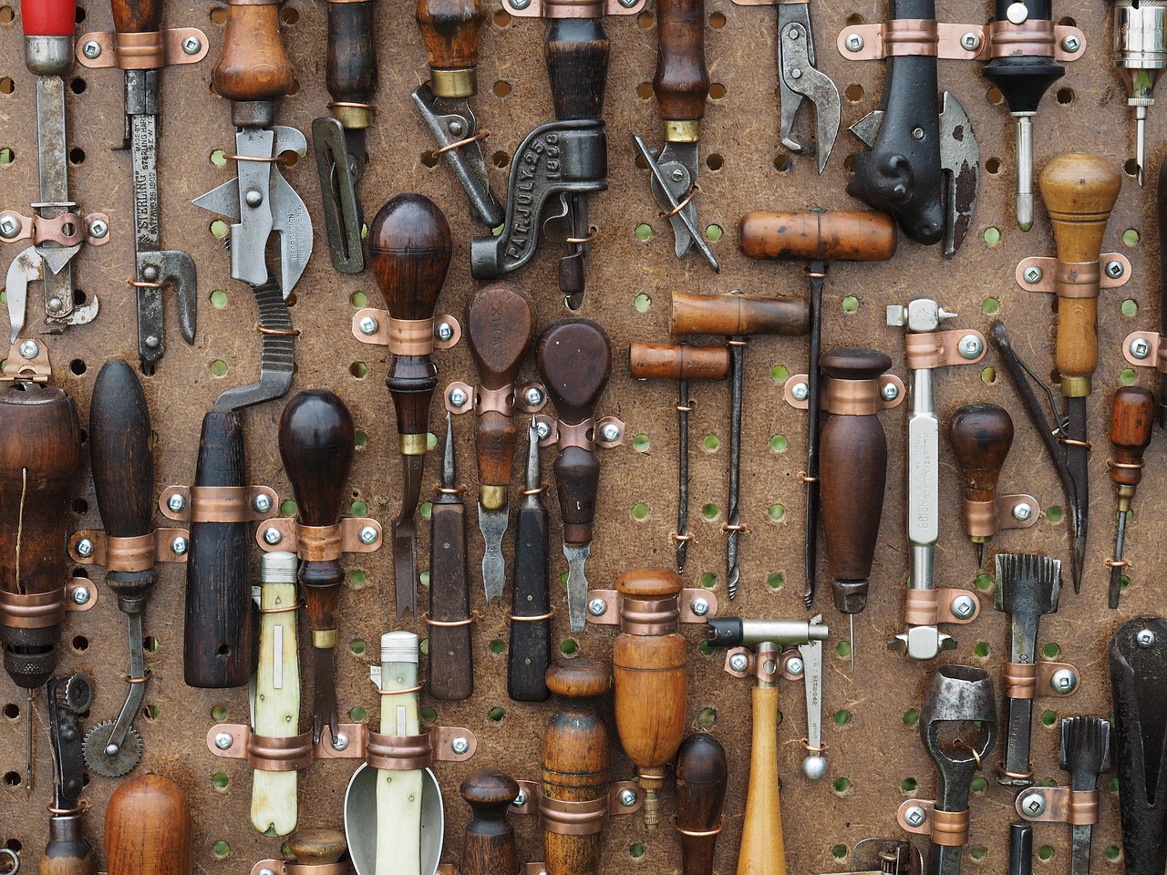 Old hand tools — awl, pliers and punches — laid out on worn leather